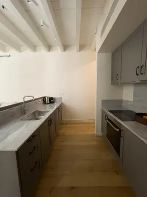 a kitchen with white cabinets and a sink and counters at Bigtrel Athens in Athens