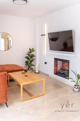 a living room with a fireplace and a tv at Seaside Luxury - 3 Min to Freatida Beach in Piraeus