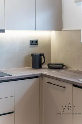 a kitchen with white cabinets and a coffee pot on the counter at Seaside Luxury - 3 Min to Freatida Beach in Piraeus