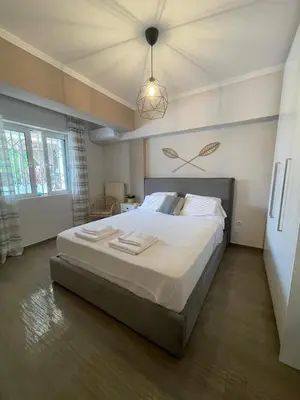 a bedroom with a large bed in a room at Modern Apartment in Agia Marina Koropi in Aghia Marina