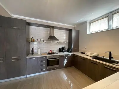 a kitchen with stainless steel appliances and wooden cabinets at Modern Apartment in Agia Marina Koropi in Aghia Marina