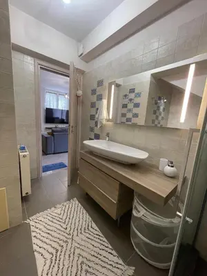 a bathroom with a sink and a mirror at Modern Apartment in Agia Marina Koropi in Aghia Marina