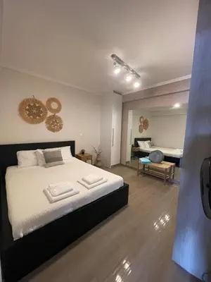 a bedroom with a large bed and a living room at Modern Apartment in Agia Marina Koropi in Aghia Marina