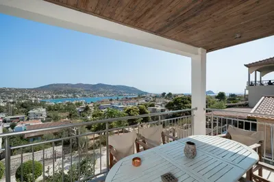 a balcony with a table and a view of the city at Kalesma Hilltop Apartment by A&D Properties in Porto Rafti