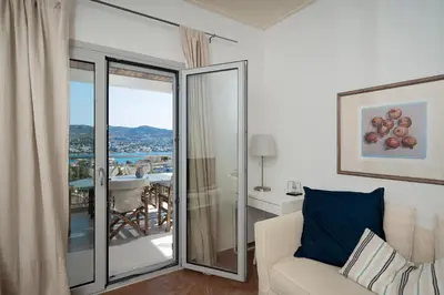 a living room with a couch and a balcony at Kalesma Hilltop Apartment by A&D Properties in Porto Rafti