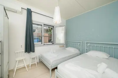 a bedroom with two beds and a window at Kalesma Hilltop Apartment by A&D Properties in Porto Rafti
