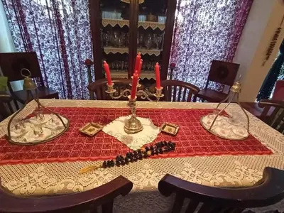a table with two candles on a red table cloth at Anatoli Hotel in Agia Marina Aegina