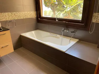 a bath tub in a bathroom with a window at Sunset Villa in Saronida
