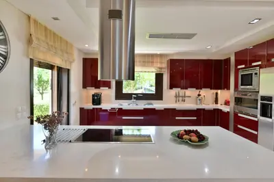 a kitchen with red cabinets and a bowl of fruit on a counter at Sunset Villa in Saronida