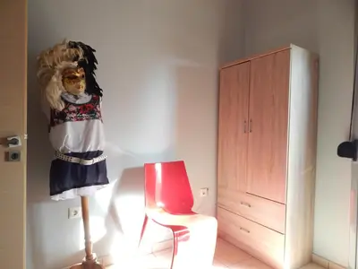 a room with a dresser and a red chair at Casa di Tsakos Luxury apartment in Athens