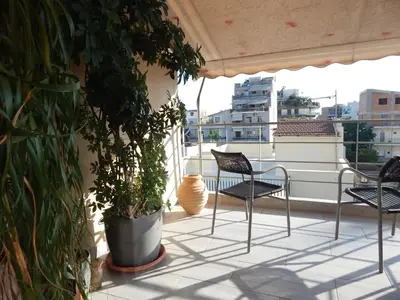 a balcony with two chairs and a plant at Casa di Tsakos Luxury apartment in Athens