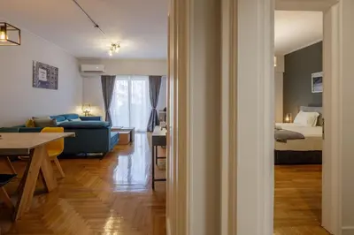a living room and a bedroom with a bed and a table at KANARI street luxury living APT in Athens
