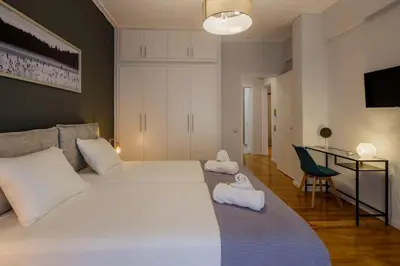 a bedroom with a large white bed and a desk at KANARI street luxury living APT in Athens