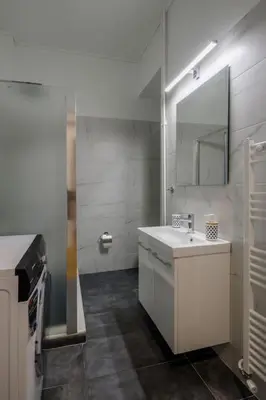 a bathroom with a white sink and a mirror at KANARI street luxury living APT in Athens