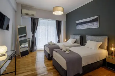 a hotel room with two beds and a television at KANARI street luxury living APT in Athens