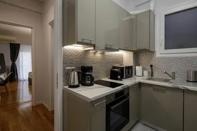 a kitchen with white cabinets and a counter top at KANARI street luxury living APT in Athens
