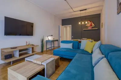 a living room with a blue couch and a table at KANARI street luxury living APT in Athens