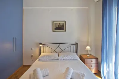 a bedroom with a bed and a dresser with a lamp at Baroness Apt Piraeus Ctr 3BR, 2BA, AC, Walk to sea in Piraeus
