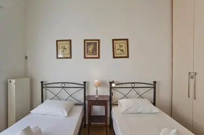two beds sitting next to each other in a room at Baroness Apt Piraeus Ctr 3BR, 2BA, AC, Walk to sea in Piraeus