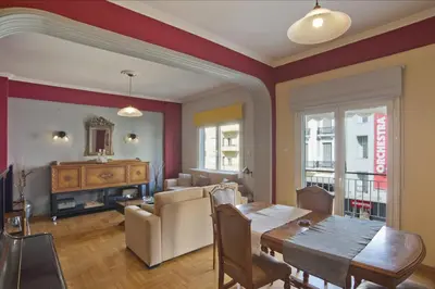 a living room with a table and a dining room at Baroness Apt Piraeus Ctr 3BR, 2BA, AC, Walk to sea in Piraeus