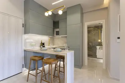 a kitchen with a counter with stools and a sink at Chrisostomou Square 14 Gold Apartment in Athens