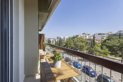 a balcony with a table and a view of a city at Chrisostomou Square 14 Gold Apartment in Athens
