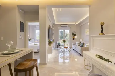 a living room with a white fireplace and a couch at Chrisostomou Square 14 Gold Apartment in Athens