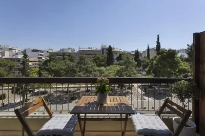 a table and chairs on a balcony with a view at Chrisostomou Square 14 Gold Apartment in Athens
