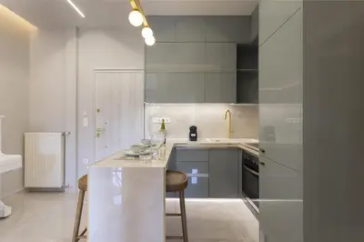 a white kitchen with a counter and a sink at Chrisostomou Square 14 Gold Apartment in Athens
