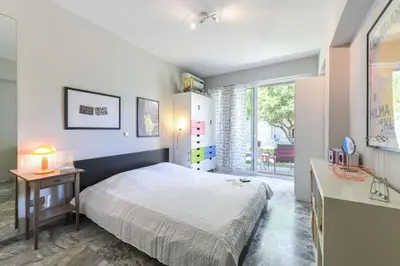 a bedroom with a bed and a table and a window at The Holiday Place in Voula for 4 by Filos Inc in Athens