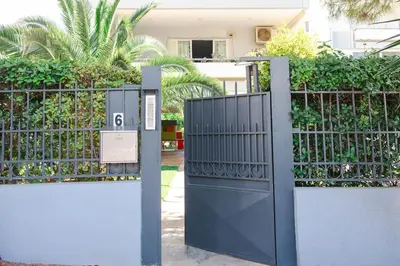 a gate with a sign in front of a house at The Holiday Place in Voula for 4 by Filos Inc in Athens