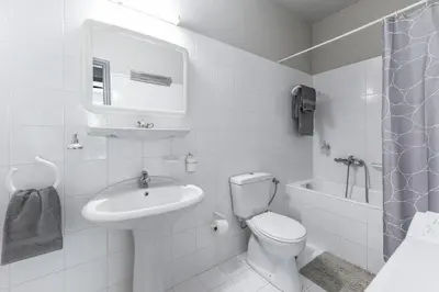 a white bathroom with a toilet and a sink at The Holiday Place in Voula for 4 by Filos Inc in Athens