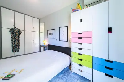 a bedroom with a white bed and a dresser at The Holiday Place in Voula for 4 by Filos Inc in Athens