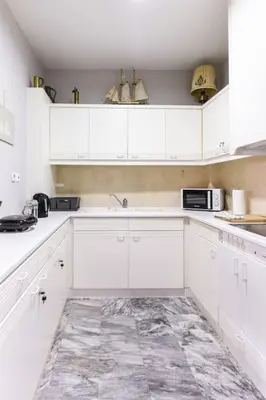 a white kitchen with white cabinets and appliances at The Holiday Place in Voula for 4 by Filos Inc in Athens
