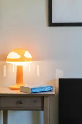 a lamp sitting on top of a table with a book at The Holiday Place in Voula for 4 by Filos Inc in Athens