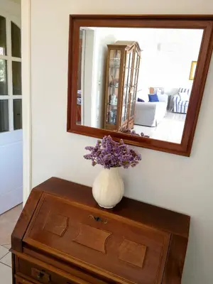 a vase of flowers sitting on a dresser under a mirror at Country House in Anavyssos in Anavissos