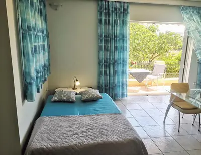 a bedroom with a bed and a table and a patio at Country House in Anavyssos in Anavissos