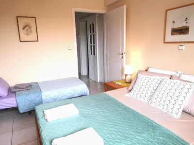 a hotel room with two beds and a doorway at Country House in Anavyssos in Anavissos