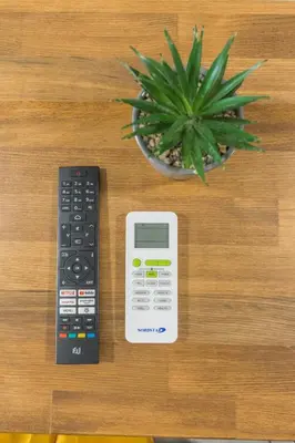 a remote control next to a calculator and a potted plant at Raise Piraeus Harbor Flats in Piraeus