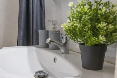 a bathroom sink with a faucet and a potted plant at Raise Piraeus Harbor Flats in Piraeus
