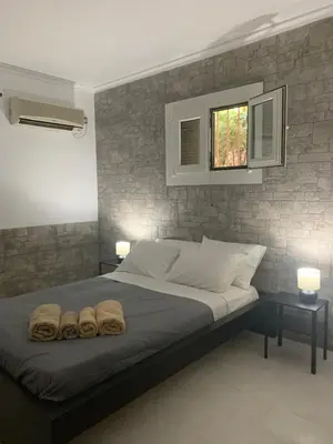 a bedroom with a bed with two towels on it at Dori's Seaside Apartment in Athens