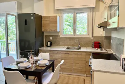 a kitchen with a table and chairs in a kitchen at Voula Casita in Athens