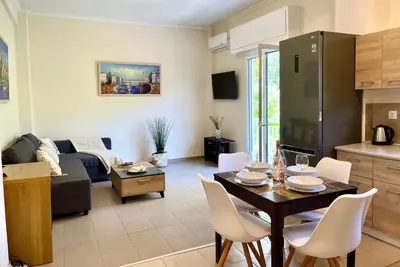 a kitchen and a living room with a table and chairs at Voula Casita in Athens