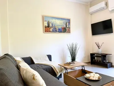 a living room with a couch and a tv at Voula Casita in Athens