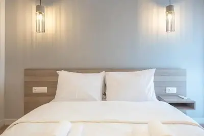 a bed with white sheets and pillows in a bedroom at Elegant Apartment in Athens