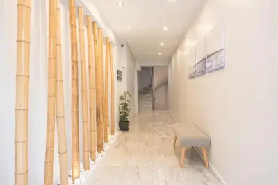 a hallway with a bench and a wall with bamboo at Elegant Apartment in Athens