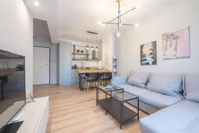 a living room with a white couch and a kitchen at Elegant Apartment in Athens