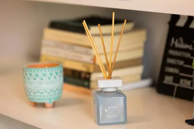 a bottle of perfume sitting on a table with books at Simpli-city home in Piraeus