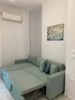 a living room with a couch and a painting on the wall at Simpli-city home in Piraeus