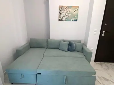 a blue couch in a room with a painting on the wall at Simpli-city home in Piraeus